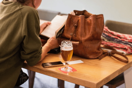 Woman reading and drinking beer